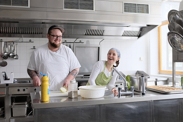 Koch und K&ouml;chin fr&ouml;hlich in der Mensa-K&uuml;che