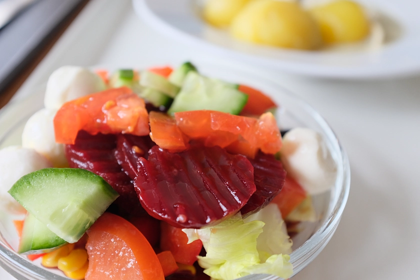 Salatbuffet mit frischen Gurken, Tomaten, Mais, roter Beete und mehr